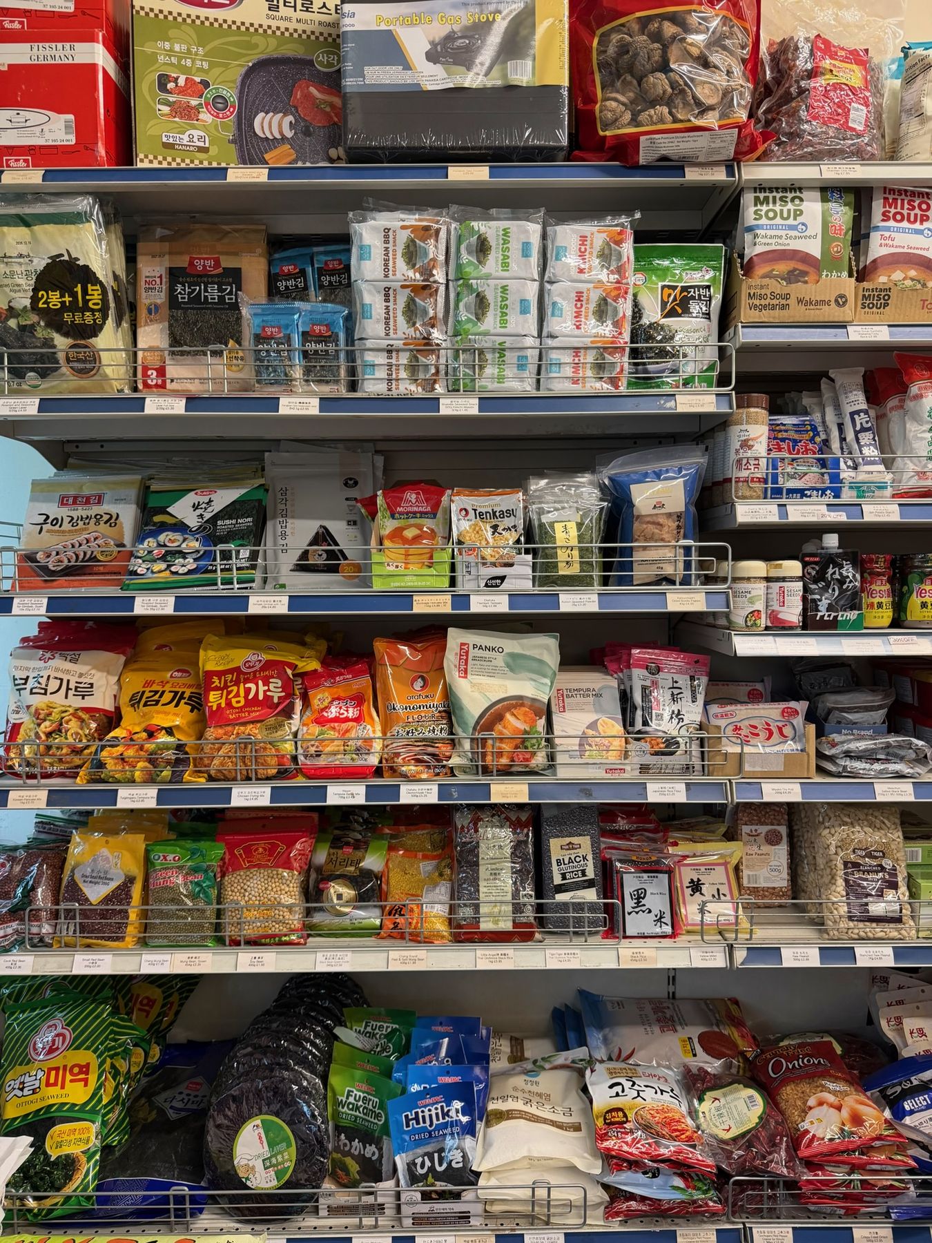 Shelves of nori, gimbap gim, katsuobushi, panko, hijiki and miyeok seaweed, dried beans, black rice, millet, peanuts, sea salt and gochugaru