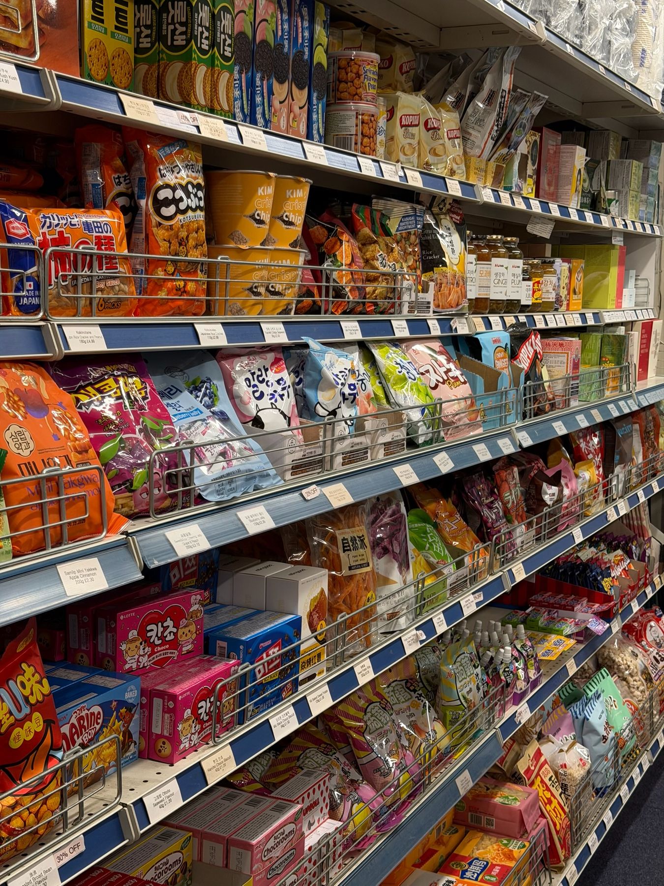 Shelves of Japanese and Korean rice crackers, crisps, biscuits and dried fruit snacks